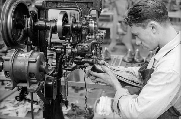 Closeup of a young worker to sew a shoe with the help of a machine inside the shoe factory Montanari, Italy, 50's 60's 